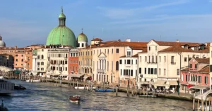 View looking down the grand canal in Venice featuring a large green dome when you exit the train station were regulators are checking for the new Venice Access Fee