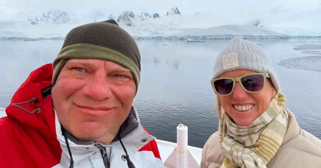Dan and Meghan on the bow of the ship in Antarctica with winter coats on